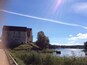 A castle by a river with a clear sky.