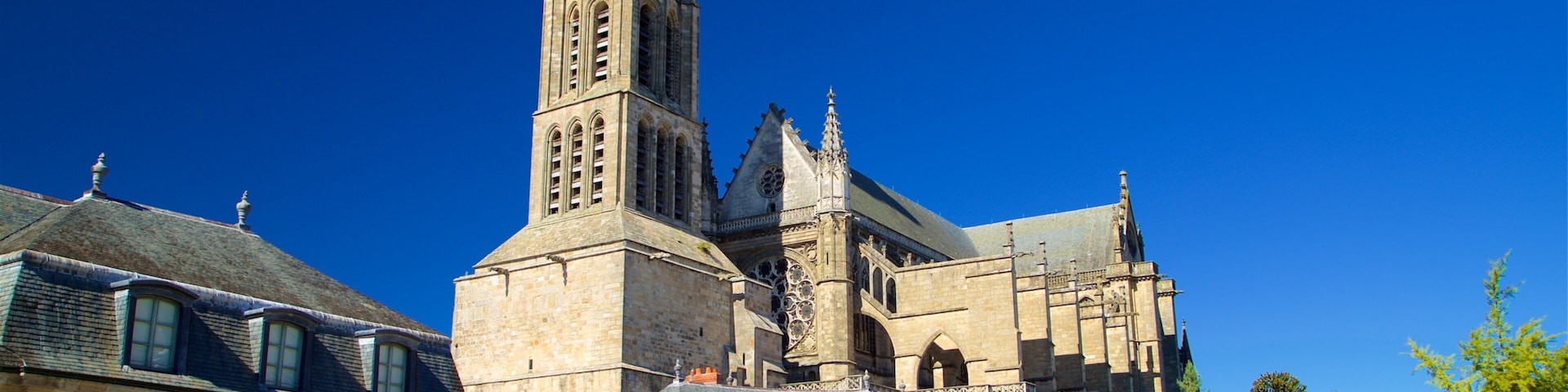 A historic church with a tall bell tower and adjacent buildings.