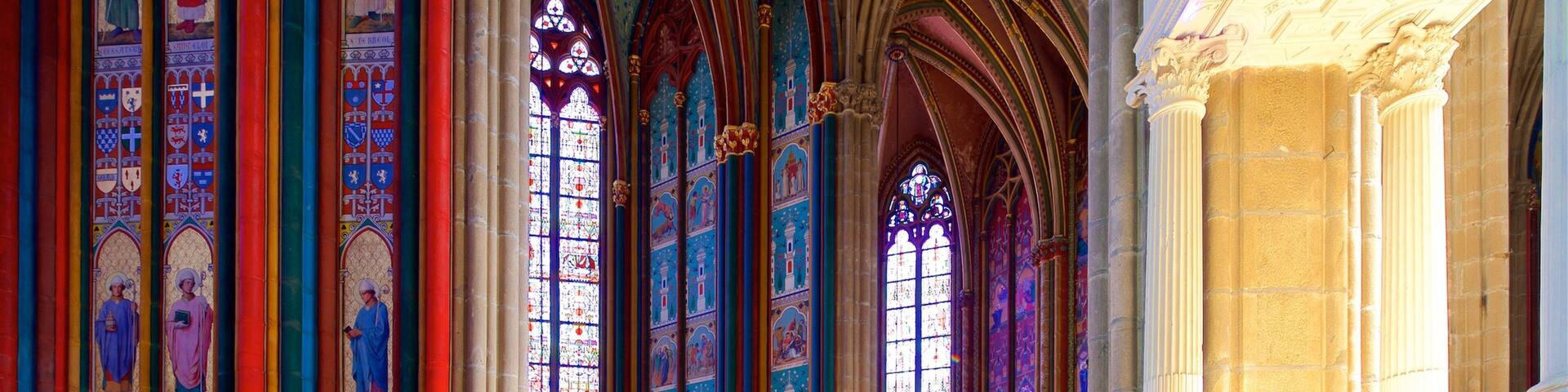 A cathedral interior with stained glass windows and Gothic arches.
