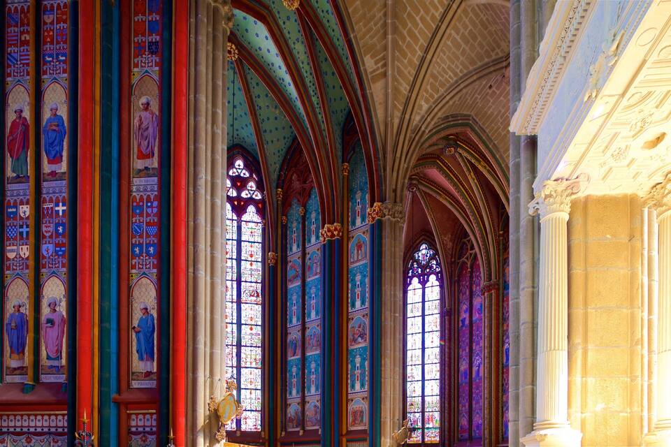 A cathedral interior with stained glass windows and Gothic arches.