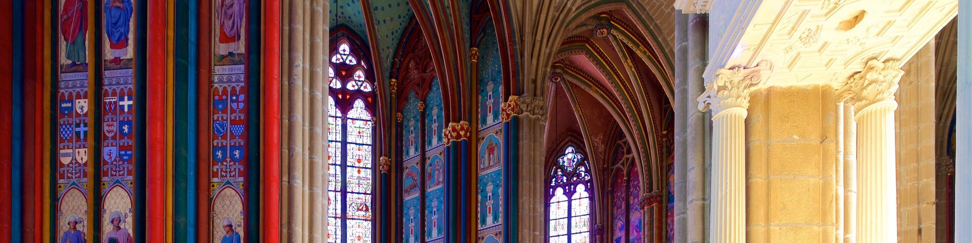 Interior de una catedral con vidrieras y arcos góticos.