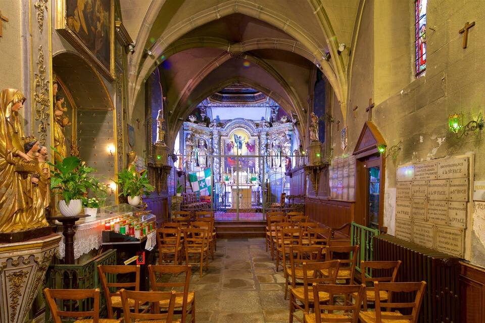 An ornate church interior with a central altar, pews, and religious statues.