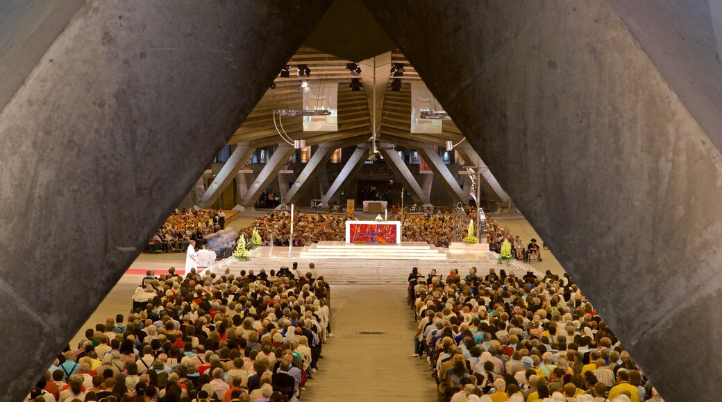 Basilica of St. Pius X which includes a church or cathedral and interior views as well as a large group of people