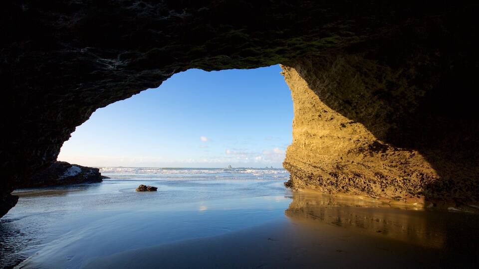 A coastal cave entrance with a view of the sea and distant islands.