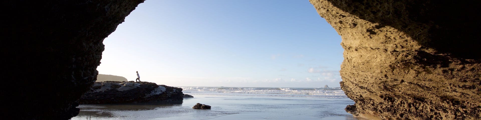 Westport showing surf, a beach and rocky coastline