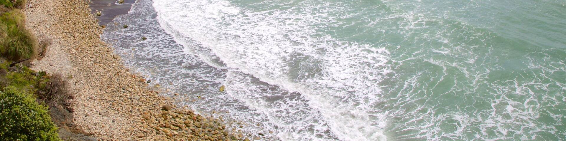 Westport showing rugged coastline, waves and a pebble beach