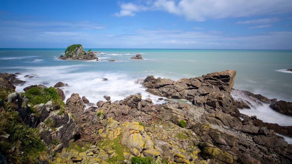 A rocky coastline with a clear blue sky and calm sea.