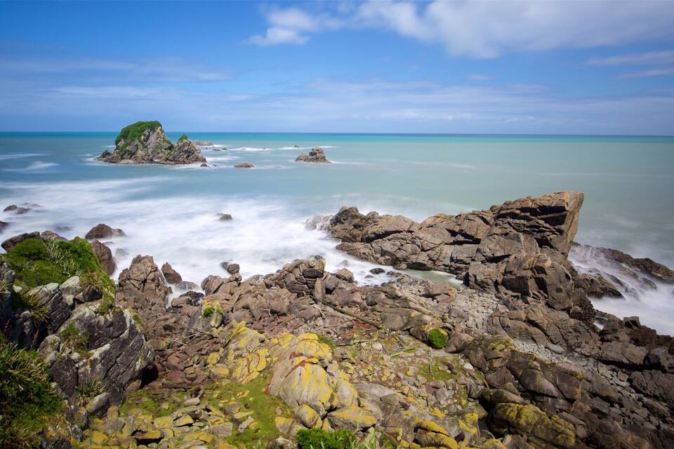 A rocky coastline with a clear blue sky and calm sea.