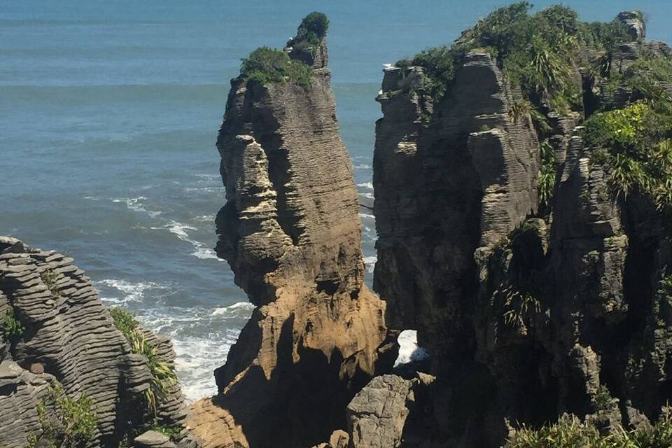 A coastal landscape with prominent rock formations and the ocean.