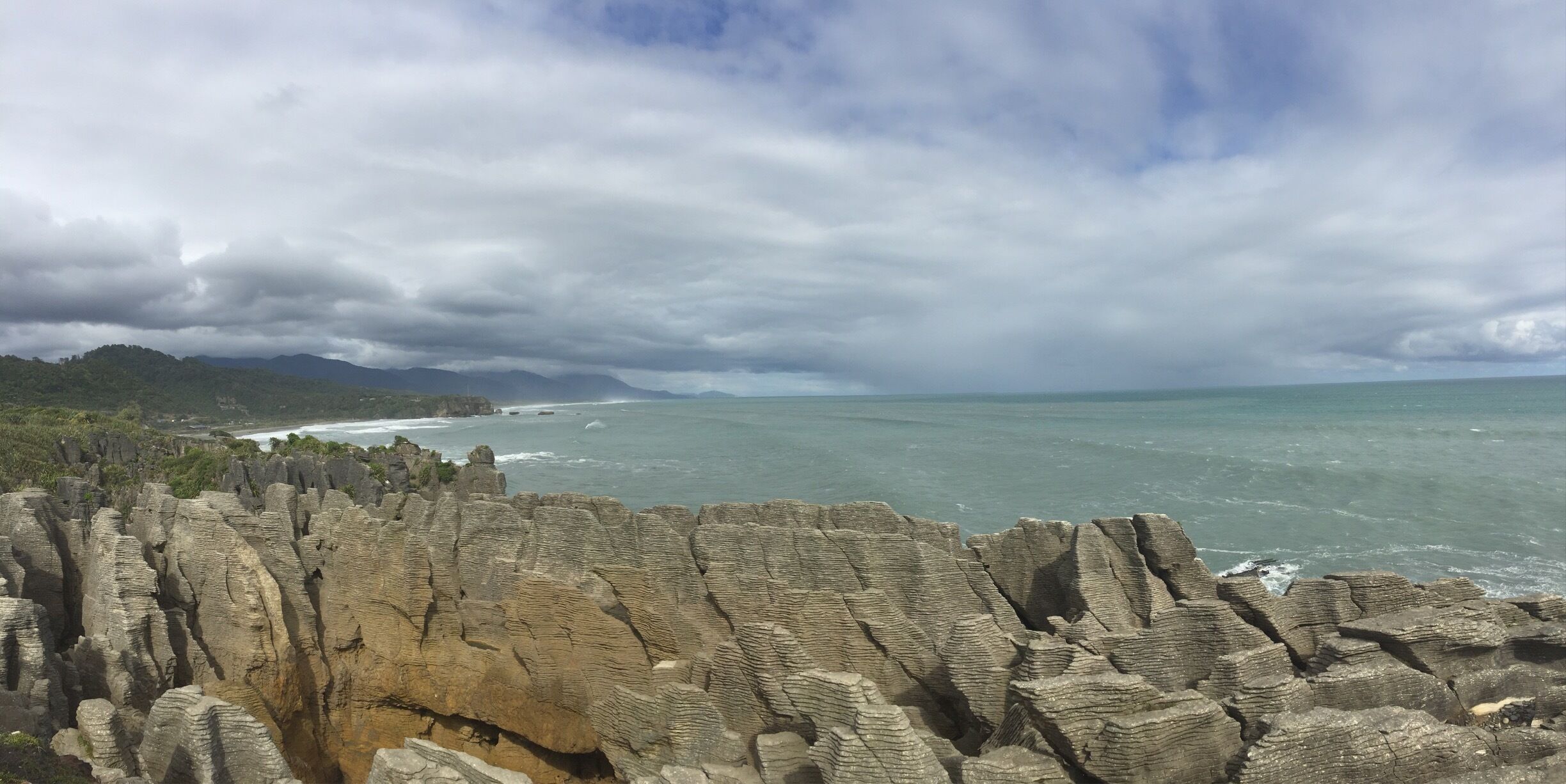 A coastal landscape with distinctive rock formations and a view of the ocean.