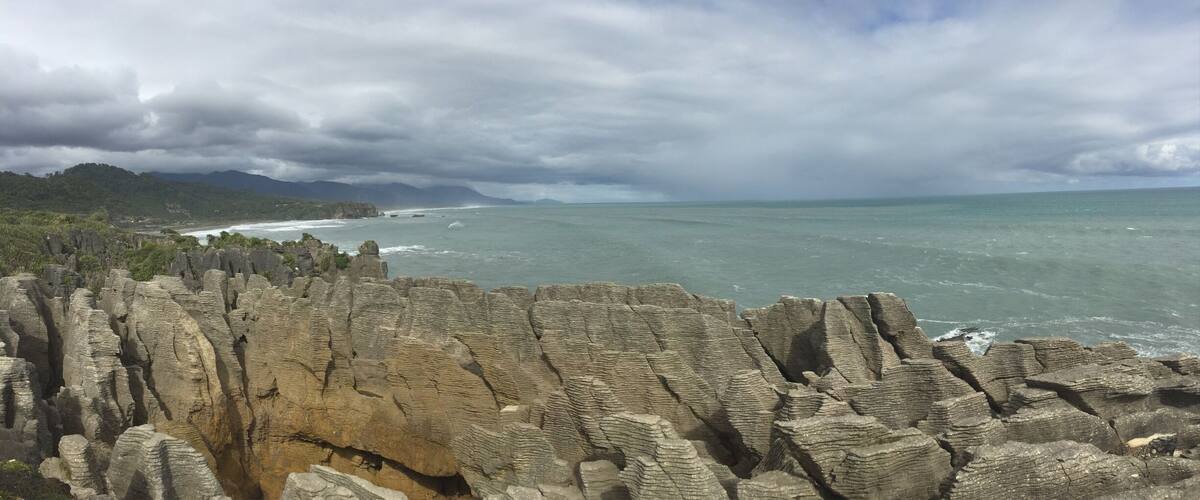 A coastal landscape with distinctive rock formations and a view of the ocean.