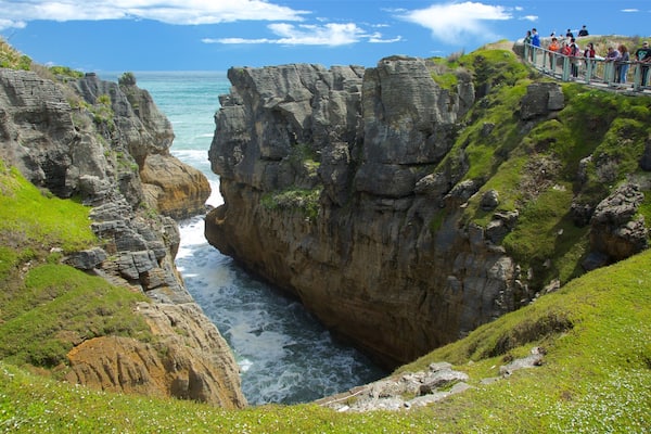 A coastal cliff with a narrow passage between two rock formations.