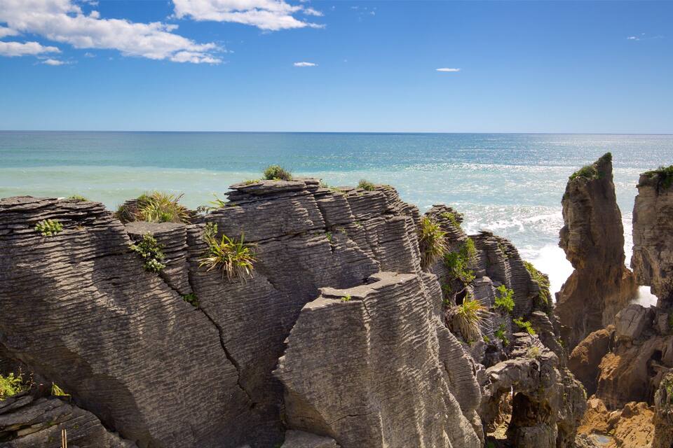 A coastal landscape with prominent rock formations and the ocean.