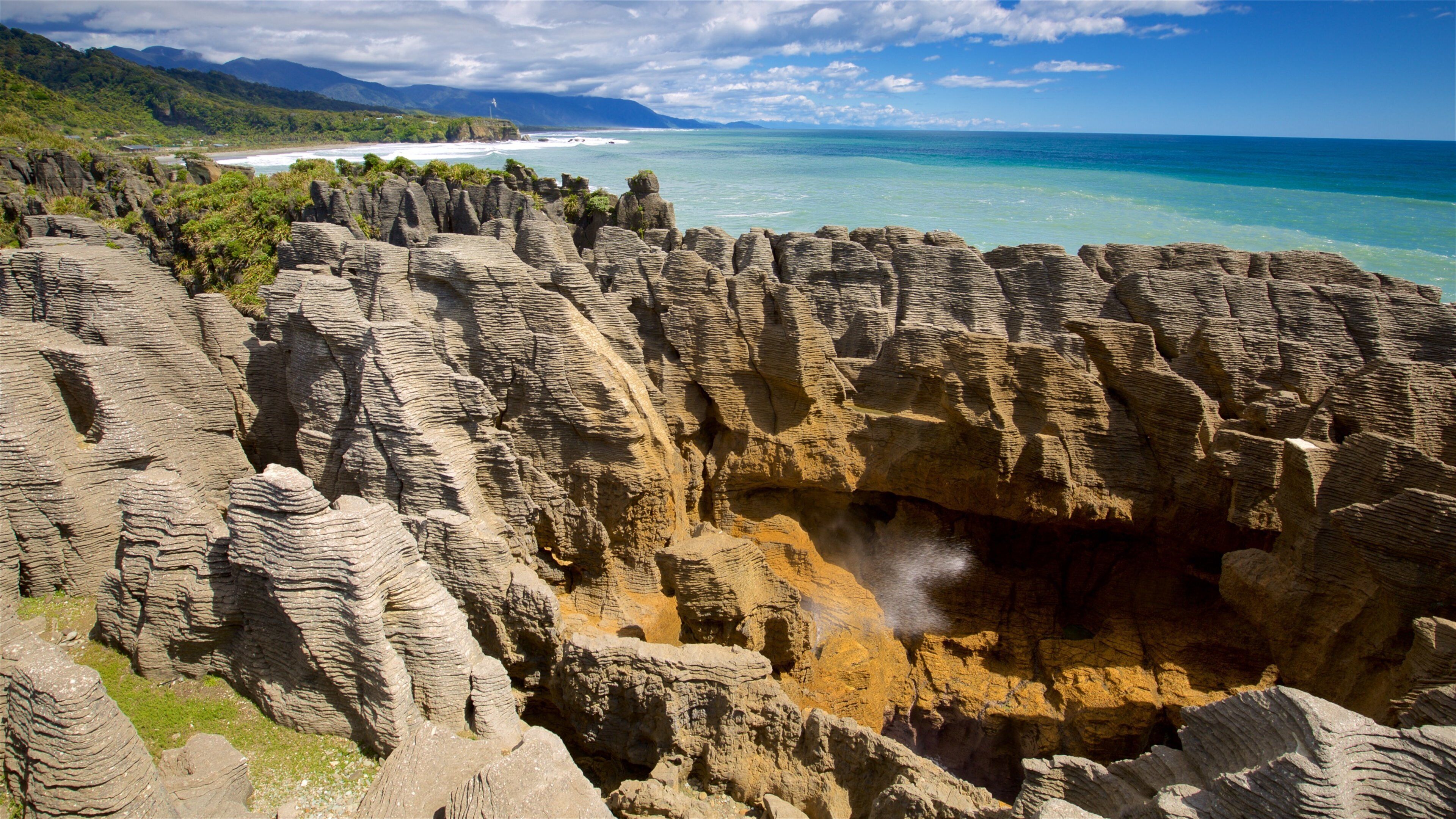 Pancake Rocks qui includes montagnes, côte escarpée et baie ou port