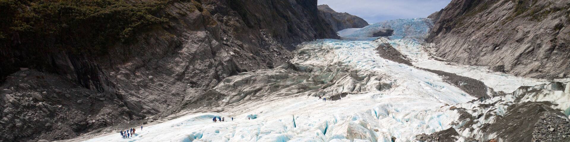 Un glaciar con senderistas caminando sobre su superficie.