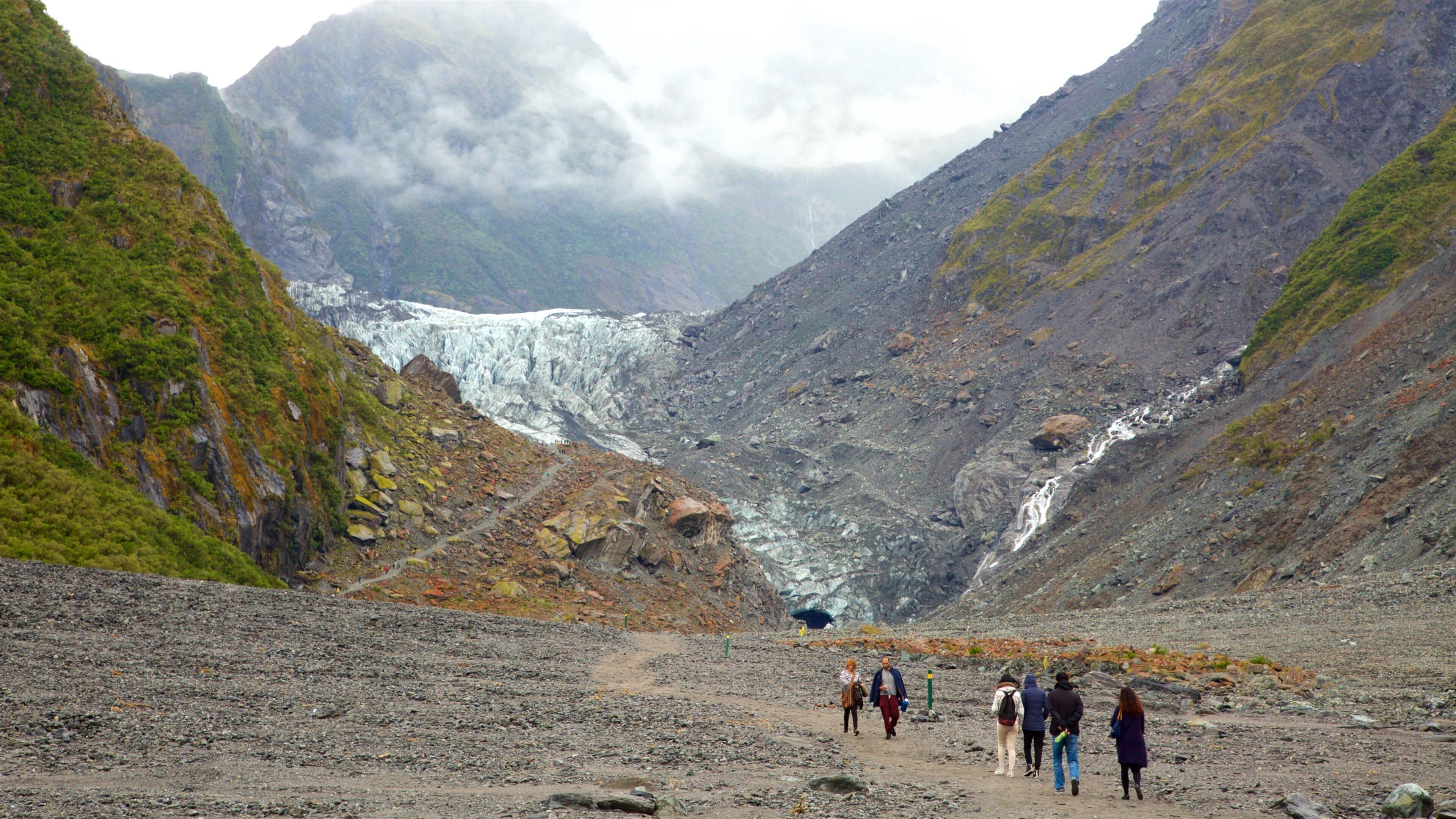 Fox Glacier featuring mist or fog, a cascade and mountains