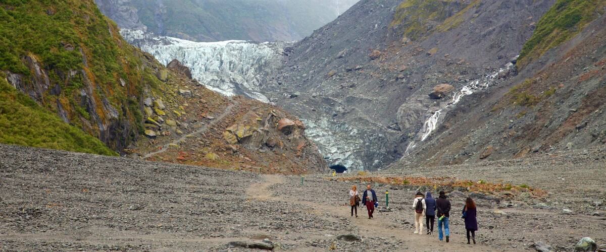 Fox Glacier featuring a cascade, mist or fog and mountains