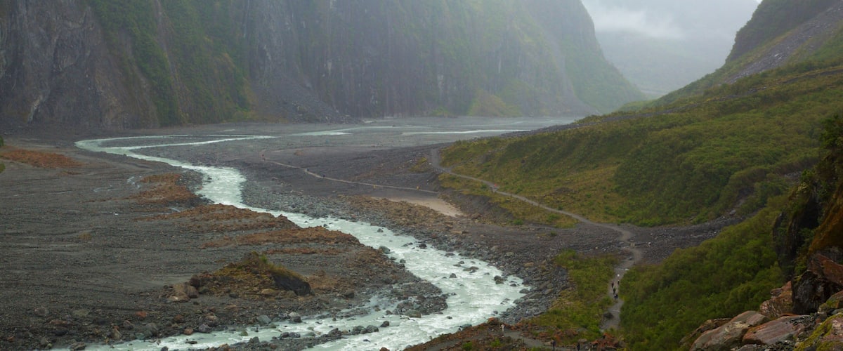 Fox Glacier showing mist or fog, mountains and a river or creek