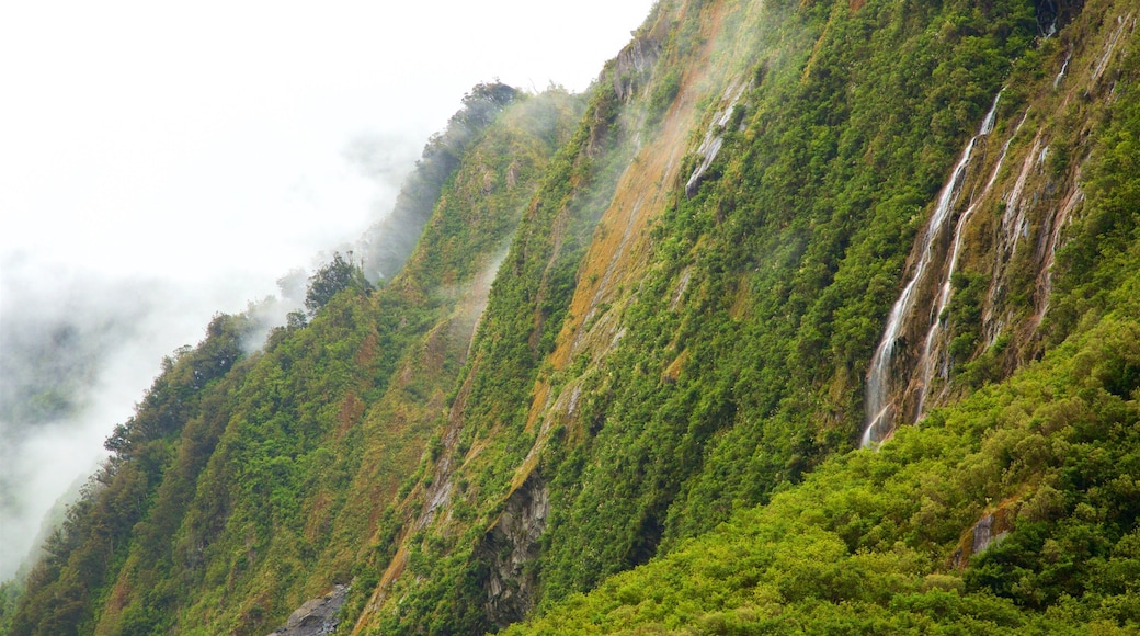 Fox Glacier featuring mist or fog, a waterfall and mountains