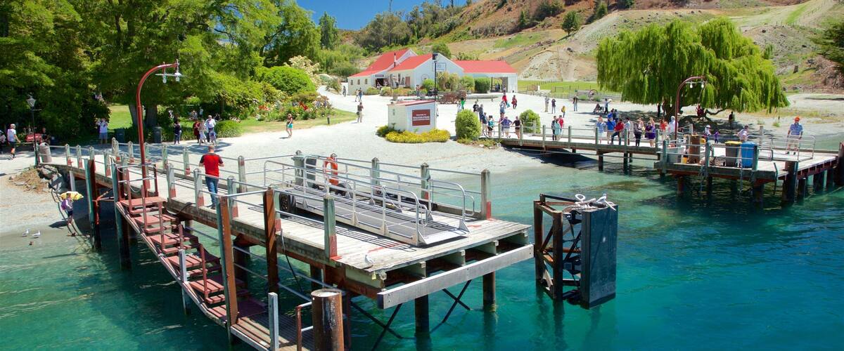 A pier extending into clear blue water with people walking on it.