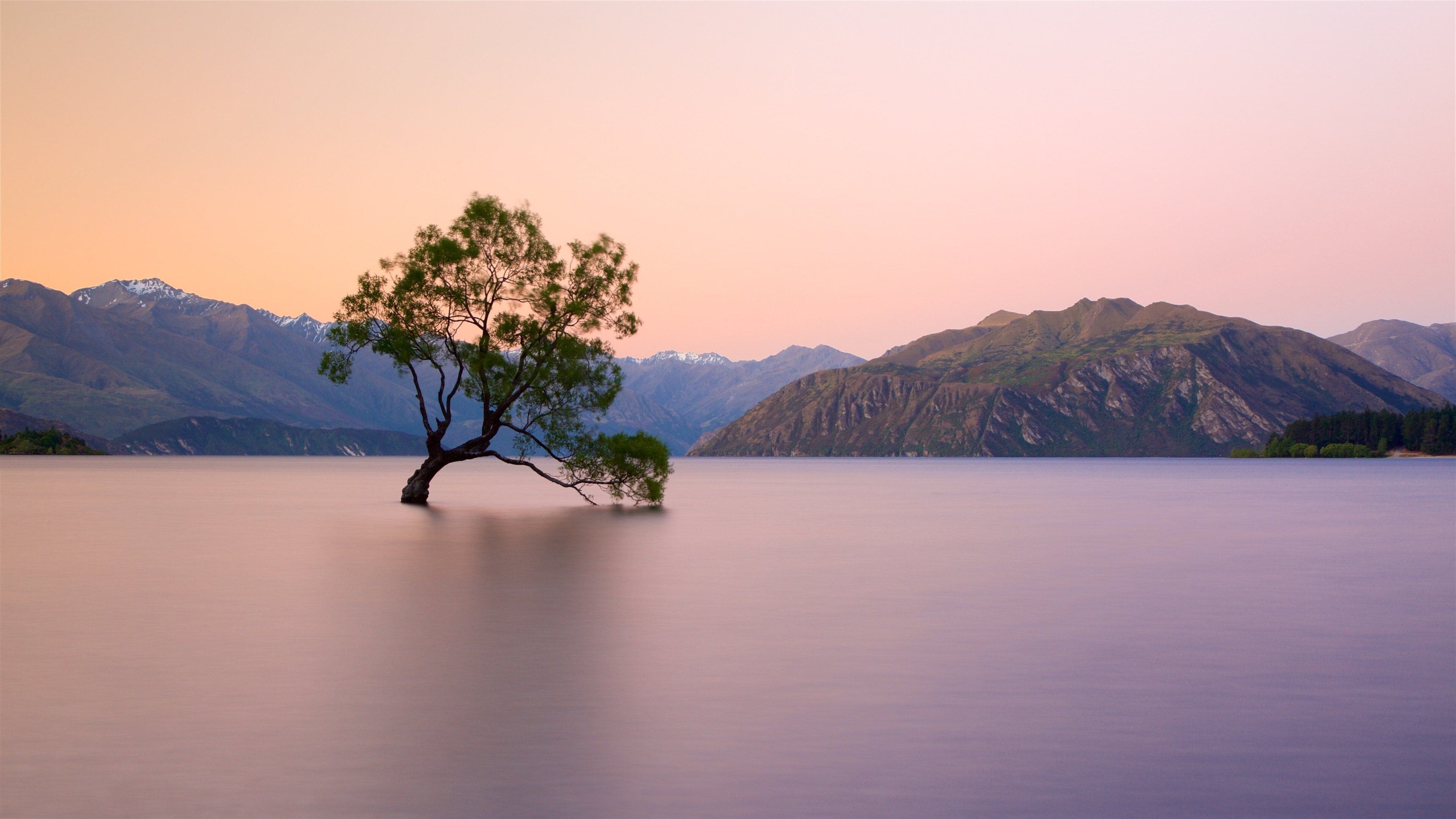 Lake Wanaka featuring mountains, a lake or waterhole and a sunset