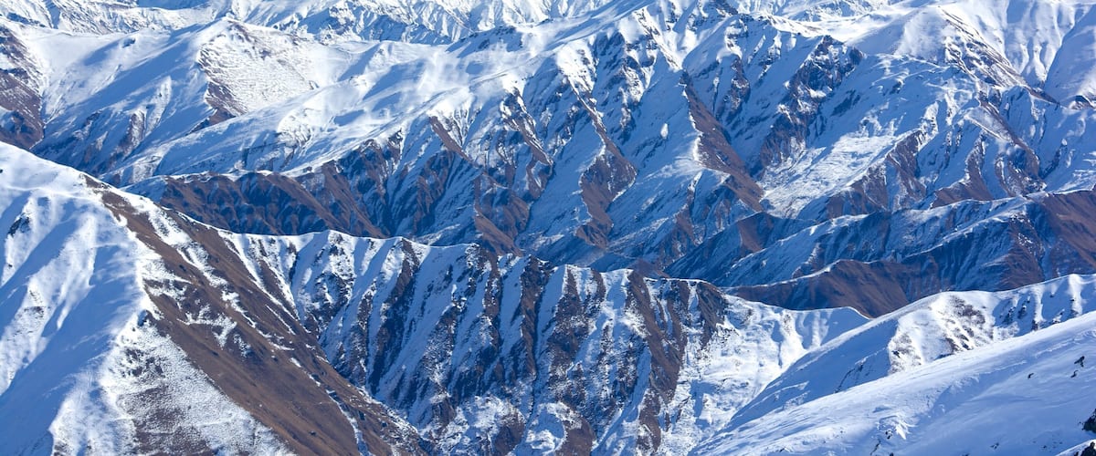 A snow-covered mountain range with rugged peaks and valleys.