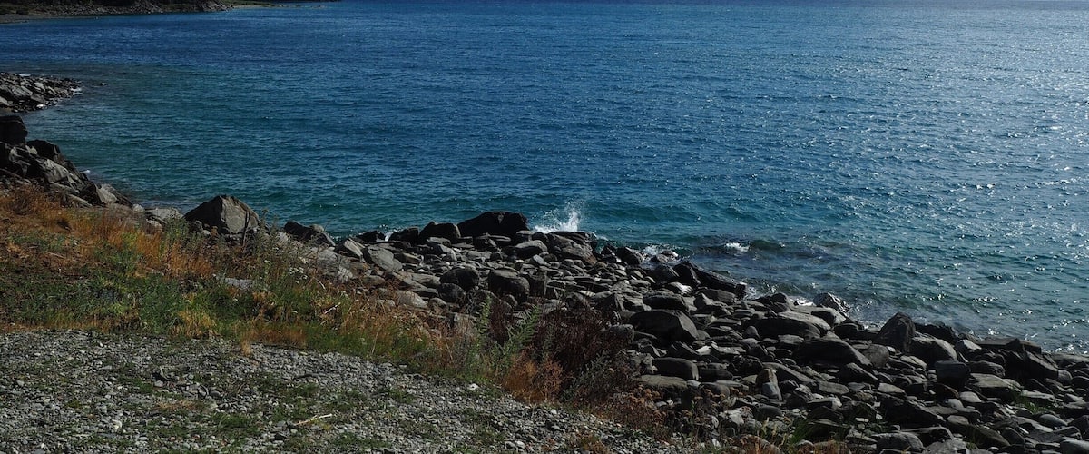 A lake surrounded by mountains and rocky shores.