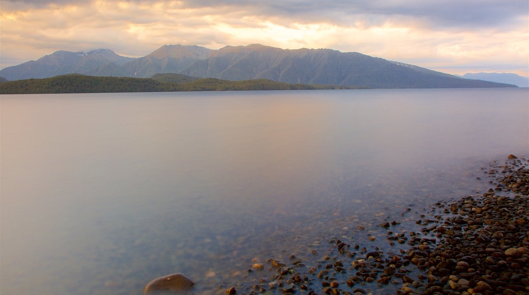 Lake Te Anau which includes a sunset, mountains and a lake or waterhole