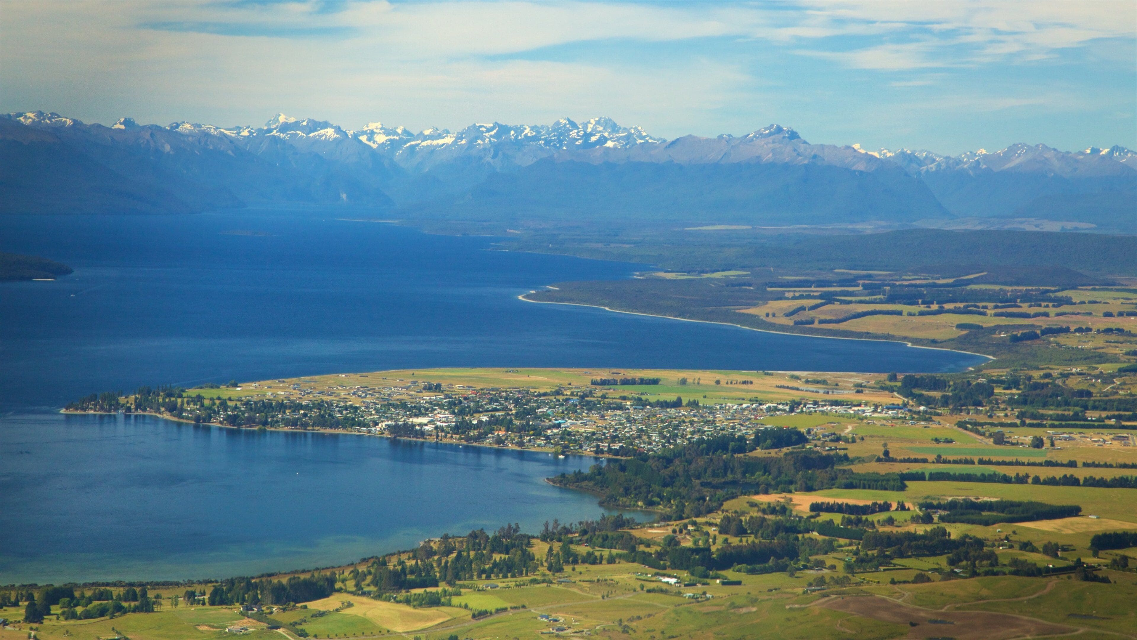 Lake Te Anau which includes a lake or waterhole, mountains and a coastal town