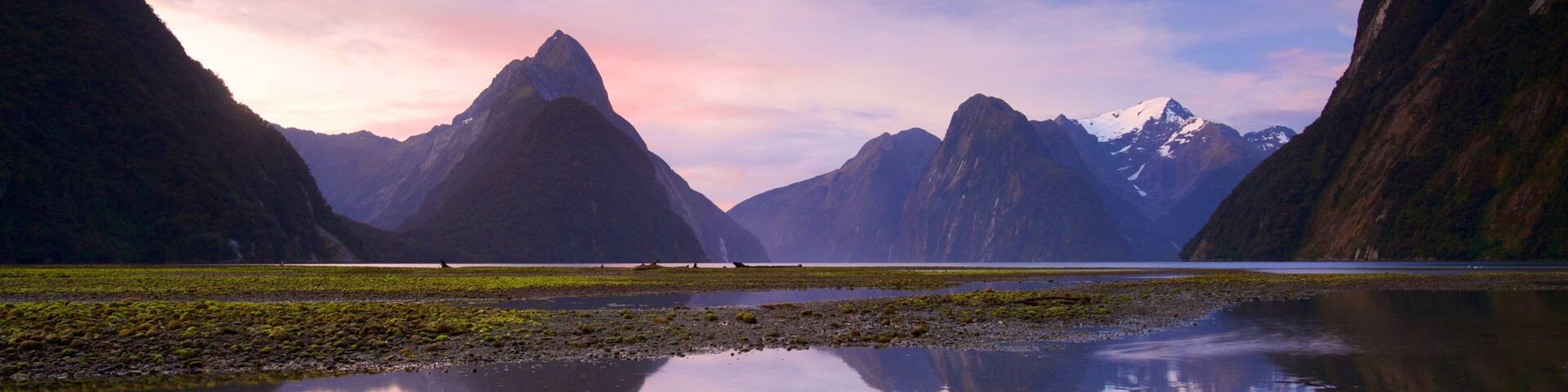 Milford Sound showing a sunset, a lake or waterhole and mountains