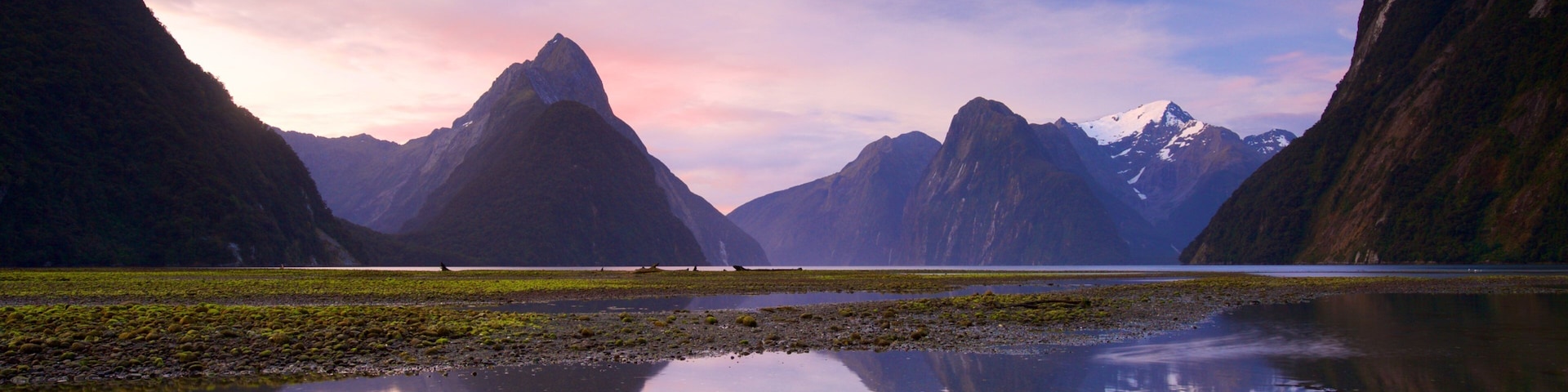 Milford Sound showing a sunset, a lake or waterhole and mountains