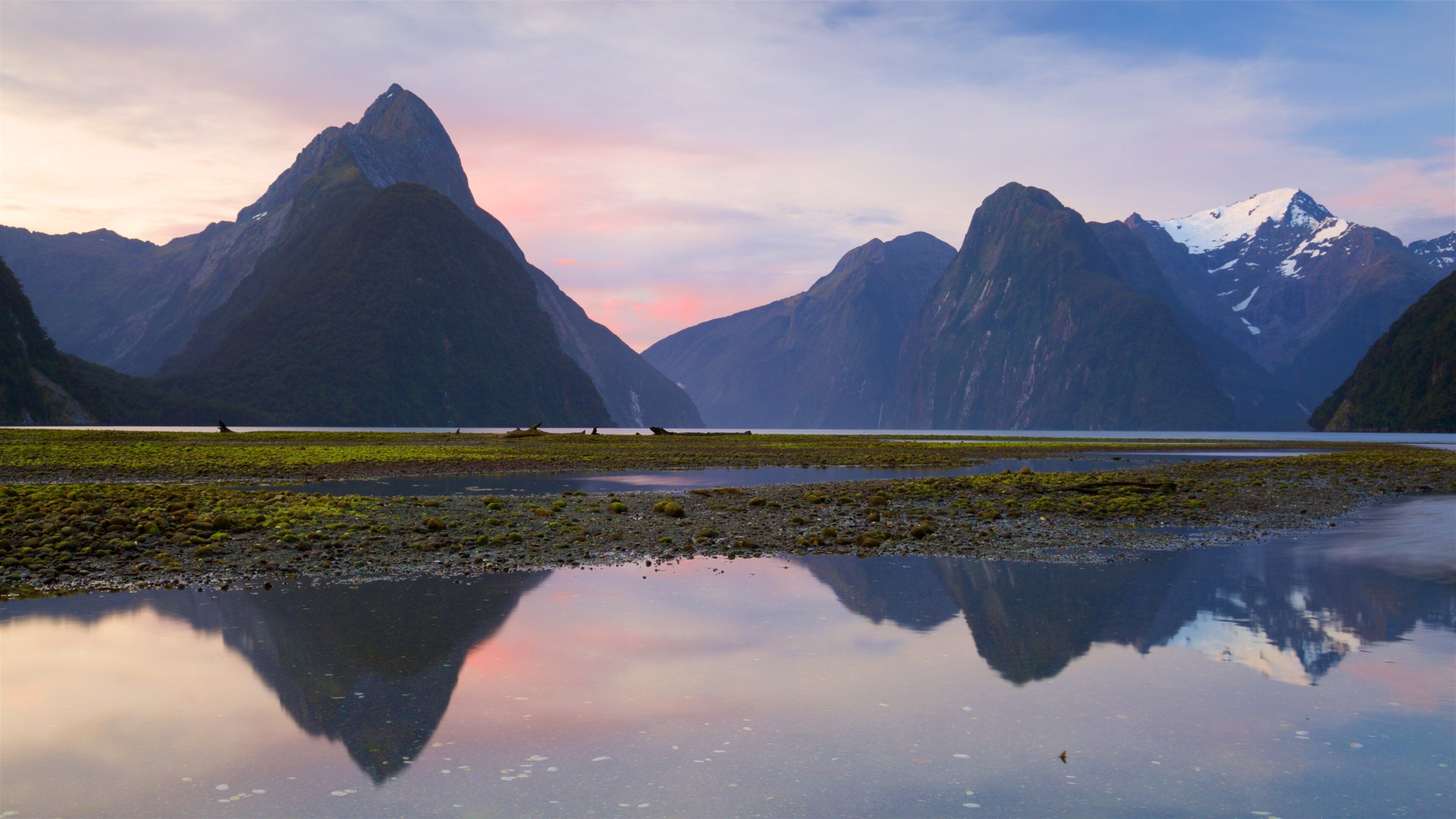 Mitre Peak which includes a pebble beach, a lake or waterhole and a sunset