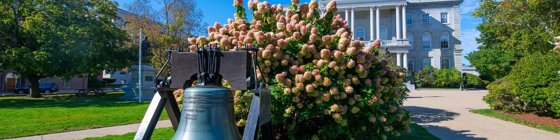Liberty Bell in front of New Hampshire State House, Concord, New Hampshire NH, USA. New Hampshire State House is the nations oldest state house, built in 1816 - 1819.