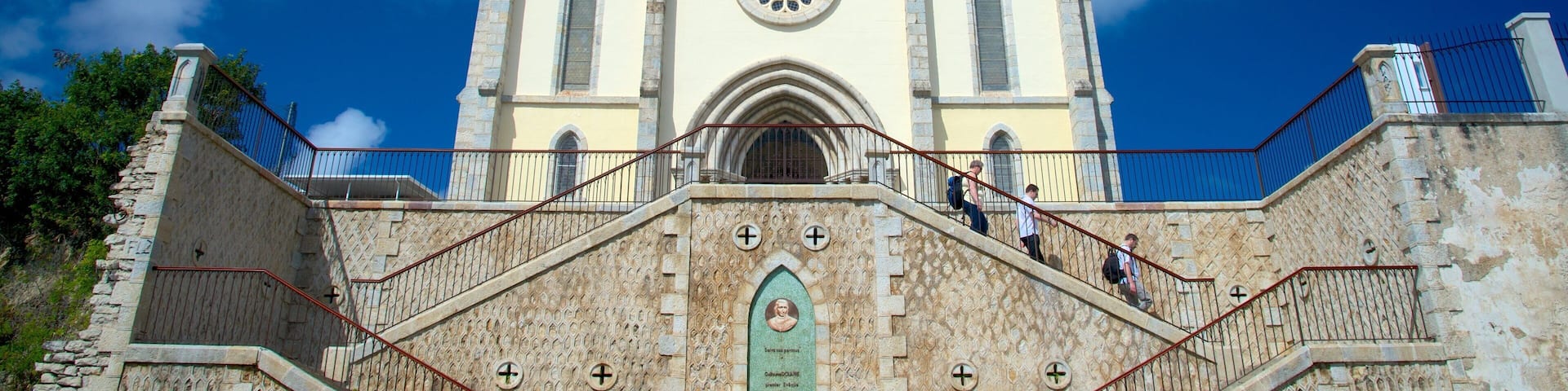 A historic church with twin towers and a central rose window.