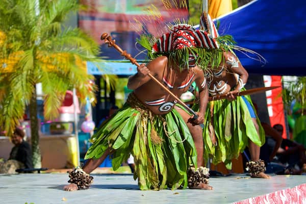 Place des Cocotiers showing performance art as well as a small group of people