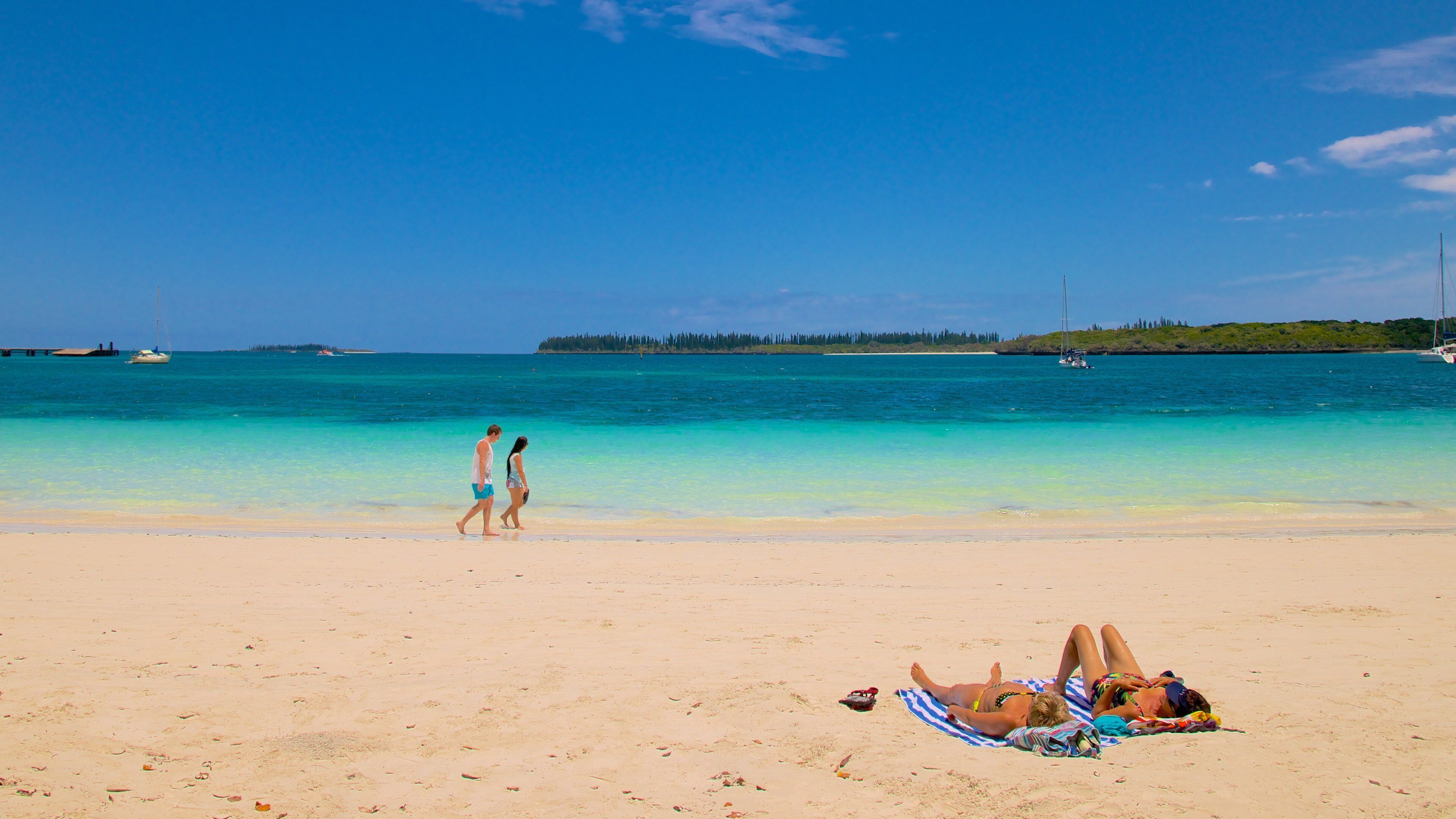 Kuto Beach featuring a sandy beach as well as a small group of people