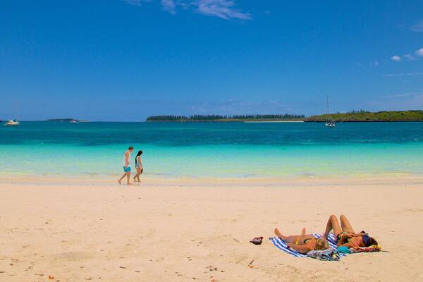 Kuto Beach featuring a sandy beach as well as a small group of people