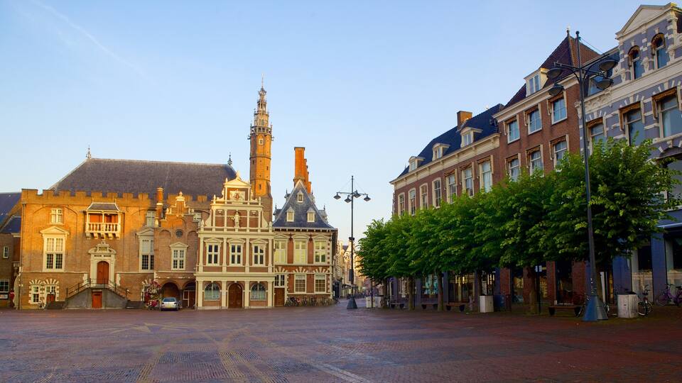 A historic square with cobblestone pavement, a prominent church with a tall tower, and traditional European architecture.
