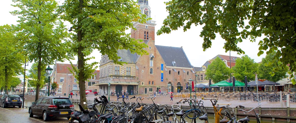 A cobblestone street lined with bicycles, a canal, and historic buildings.