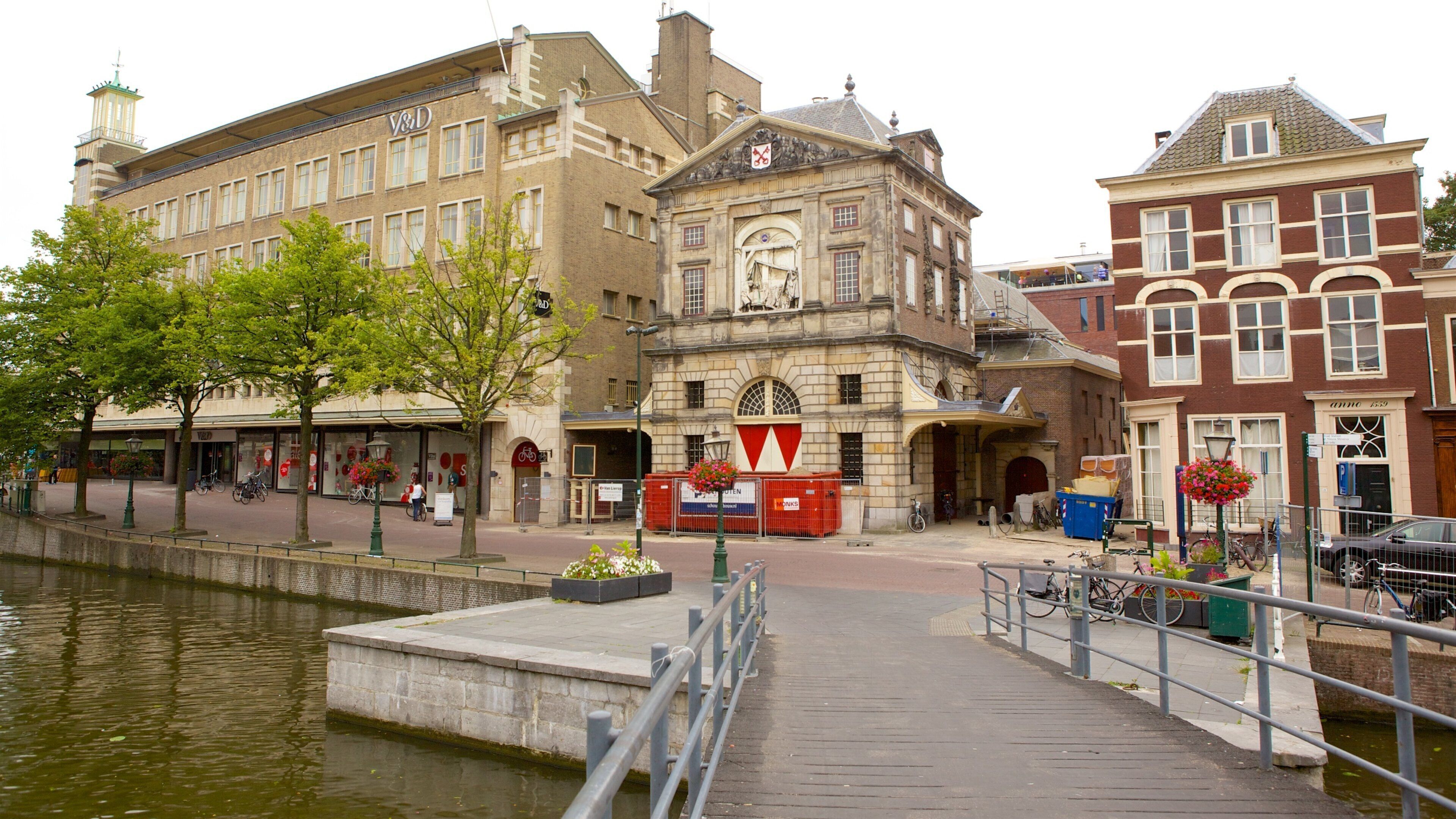 A canal with a bridge, historic buildings, and a row of shops.