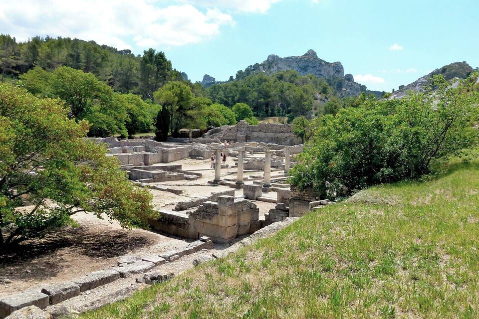 Ancient ruins surrounded by lush greenery and mountains.