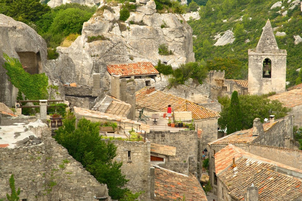 A historic village with stone buildings, terracotta roofs, and a bell tower.