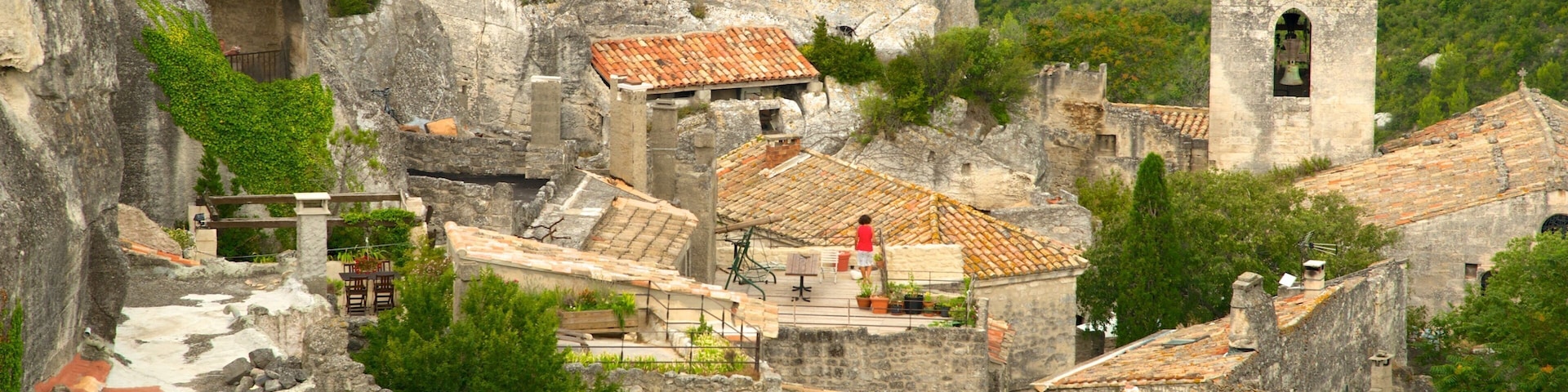 A historic village with stone buildings, terracotta roofs, and a bell tower.
