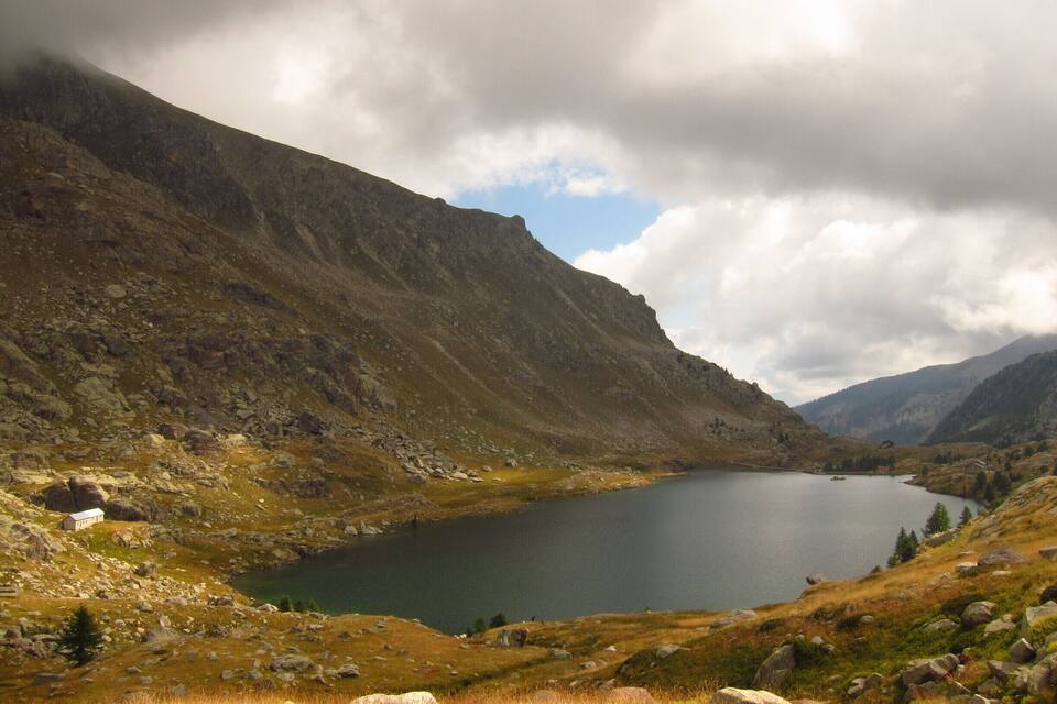 A mountain lake surrounded by rocky terrain and sparse vegetation.