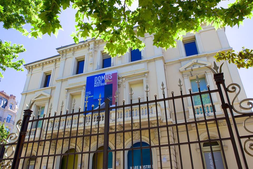 A classical building with a prominent blue banner advertising an event.