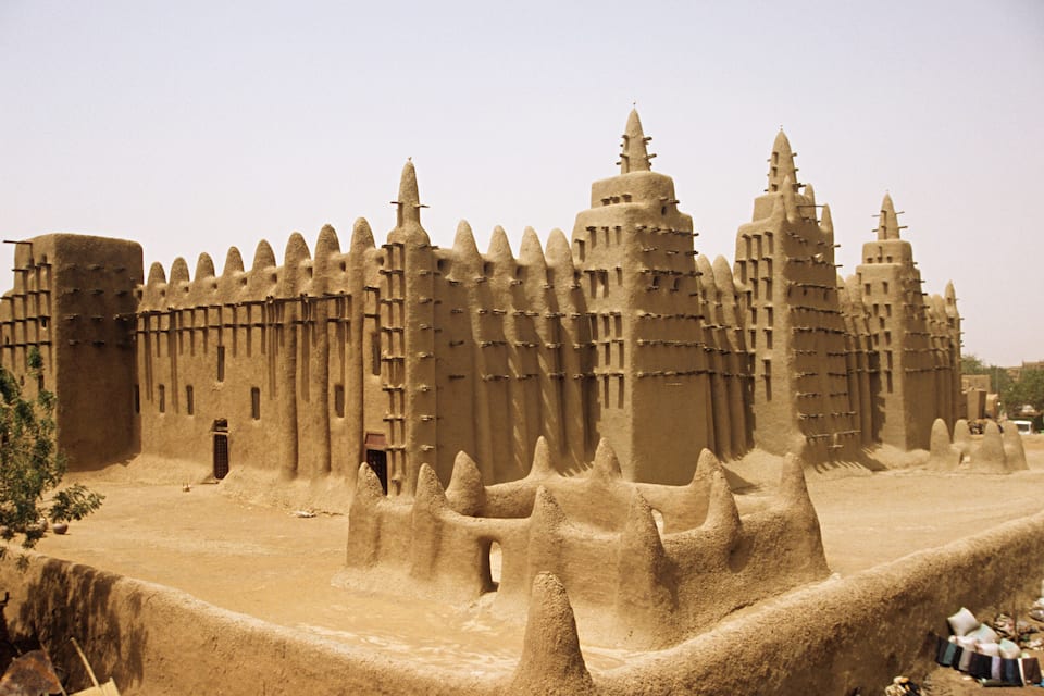 A large sandcastle with multiple towers and a surrounding wall.