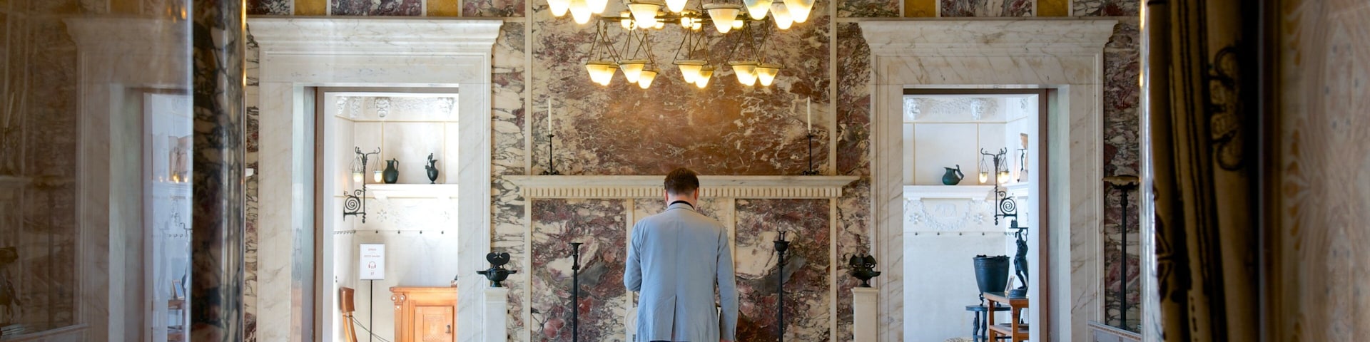 Villa Kerylos caracterizando vistas internas assim como um homem sozinho