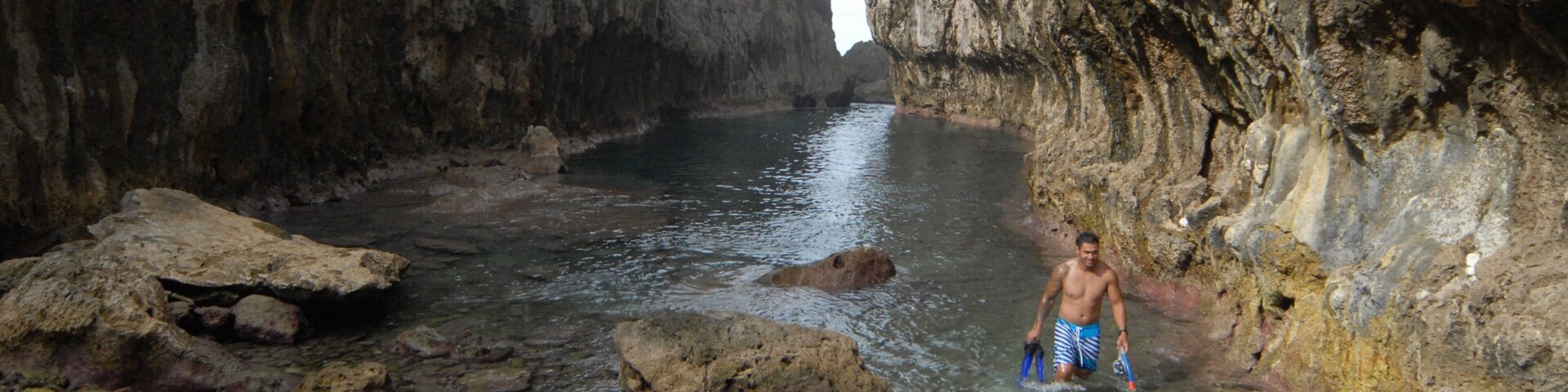 Matapa Chasm que incluye un cañón o garganta y litoral rocoso y también un hombre