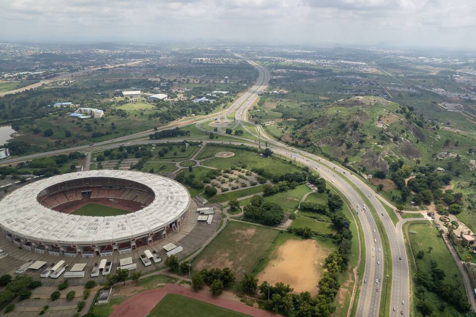 A large stadium surrounded by roads and greenery.