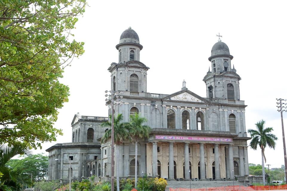 Una iglesia grande e histórica con dos cúpulas y un campanario central.